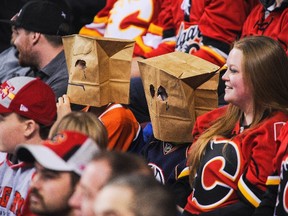People wearing Oilers jerseys also wear paper bags over their heads during an NHL game against the Calgary Flames at Scotiabank Saddledome on January 31, 2015 in Calgary, Alberta, Canada. The Flames defeated the Oilers 4-2.   Derek Leung/Getty Images/AFP
