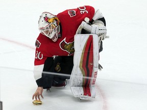 Mar 15, 2015; Ottawa, Ontario, CAN; Ottawa Senators goalie Andrew Hammond (30) picks up a hamburger that was thrown on the ice at the end of game against the Philadelphia Flyers. The Senators defeated the Flyers 2-1 in a shoot-out at the Canadian Tire Centre. Mandatory Credit: Marc DesRosiers-USA TODAY Sports