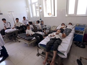 Afghan schoolboys receive treatment at a hospital after falling ill in Herat Province April 11, 2015. Authorities in western Afghanistan are investigating whether 100 schoolboys who were hospitalized on Saturday were poisoned, police said, a day after five aid workers kidnapped by the Taliban were found dead.  REUTERS/Mohammad Shoib