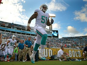 Mike Pouncey of the Miami Dolphins leads the team onto the field during a preseason game against the Jacksonville Jaguars at EverBank Field on August 9, 2013. (Mike Ehrmann/Getty Images/AFP)
