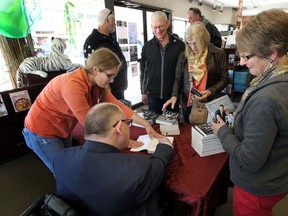 Edmonton Sun writer Cam Tait signs a copy of his book at Audrey's Books in Edmonton, Alta., on April 11, 2015, 2015. Perry Mah/Edmonton Sun/QMI Agency