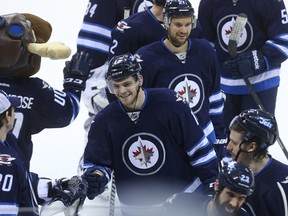 Winnipeg Jets centre Adam Lowry is all smiles leaving the ice after beating the Calgary Flames 5-1 during NHL action at MTS Centre in Winnipeg, Man., on Sat., April 11, 2015. Kevin King/Winnipeg Sun/QMI Agency