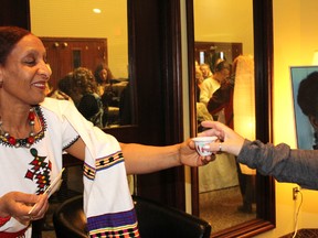 Ejigayehu Abdissa shares a cup of traditional Ethiopian coffee with a guest at the Gems and Java charity event. (File photo)