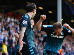 Cesc Fabregas (left) celebrates scoring the first goal for Chelsea as Branislav Ivanovic (right) is hit by a lighter thrown from the crowd during Premier League action on Sunday, April 12, 2015. (John Sibley/Action Images via Reuters)