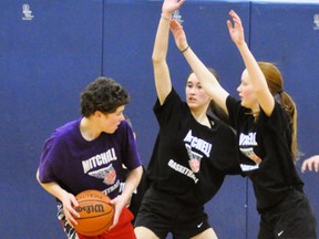 Pelicans’ Alec Murray (left) is tightly guarded by Cavaliers’ Claire Horan and Maddie Larivee (right) during action from the Mitchell Minor Basketball senior championship game April 1, a 19-11 Pelicans’ victory. ANDY BADER/MITCHELL ADVOCATE