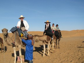 Toronto Sun's Mike Strobel (front on Bob Marley) with Carolyn McGill (behind on Jimmy) and the rest of the group pause while Berber guide Hamid (in blue) checks to make sure everything is ready for the desert trek.