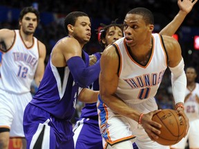 Thunder guard Russell Westbrook (front) handles the ball against Kings guard Ray McCallum (left) during fourth quarter NBA action in Oklahoma City on Friday, April 10, 2015. (Mark D. Smith/USA TODAY Sports)