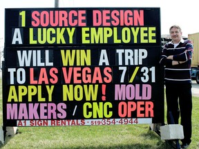 1 Source Design in Wallaceburg, Ont., is in such dire need of new employees it is offering the chance to win a trip to Las Vegas as an enticement to attract applicants. Plant manager Dale Bowers is pictured Monday, April 13, 2015, with a sign the company has on Baseline Road, in Wallaceburg, Ont., promoting the offer.  Photo Taken Monday April 13, 2015. (Ellwood Shreve/Chatham Daily News/Postmedia Network)