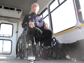 Henk Wevers, one of the original designers of Q'Straint, a system of securing wheelchairs to an accessible vehicle, tries out a wheelchair that is using the system on a Kingston Access Bus. (Michael Lea/The Whig-Standard)