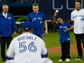 MLB commissioner Rob Manfred (left) watches as youngster Ben Sheppard throws out the first pitch during the Blue Jays home opener against the Tampa Bay Rays last night. (Stan Behal/Toronto Sun)
