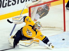 Nashville Predators goalie Carter Hutton watches the puck slide through the crease during the first period against the Calgary Flames at Bridgestone Arena on March 29, 2015. (Christopher Hanewinckel/USA TODAY Sports)