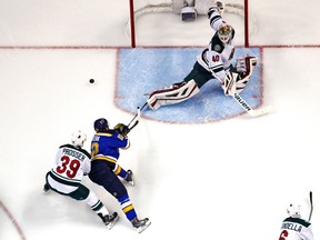 Minnesota Wild goalie Devan Dubnyk reaches back to block a shot by St. Louis Blues center Jori Lehtera as he is being defended by Nate Prosser (39) during the second period at Scottrade Center on April 11, 2015. (Billy Hurst/USA TODAY Sports)