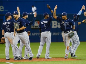 Members of the Tampa Bay Rays celebrate on the new artificial turf at the Rogers Centre in Toronto after defeating the Blue Jays 2-1 on April 13, 2015. (STAN BEHAL/Toronto Sun)