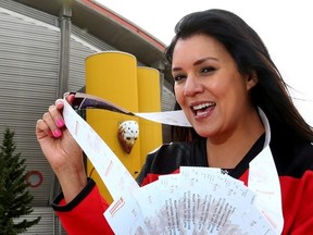 Tracy Wood, Executive for Ticket Sales, holds up the hottest ticket in town for Sunday's playoff game against the Vancouver Canucks at the Scotiabank Saddledome in Calgary, Alta. on Monday April 13, 2015. Darren Makowichuk/Calgary Sun/Postmedia Network