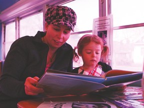 Lori Gair and her daughter, Nora, age 3, partake in one of the many reading related activities on the C.O.W. bus during one of the stops in Vulcan at the Vulcan Municipal Library.
