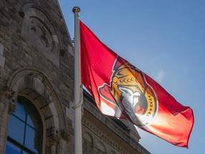 Mayor Jim Watson and other city council members raised an Ottawa Senators flag in front of the Heritage Building at City Hall in Ottawa on April 14, 2015. (Joel Watson/Ottawa Sun/PostMedia Network)