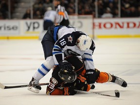Bryan Little #18 of the Winnipeg Jets fights with Jakob Silfverberg #33 of the Anaheim Ducks during their NHL game at Honda Center on January 11, 2015 in Anaheim, California.