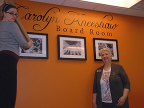 St. Thomas Public Library marketing coordinator Ruth Crocker, left, and CEO/chief librarian Rudi Denham unviel the artwork in the second floor board room dedicated in the memory of of long-serving former CEO/chief librarian Carolyn Kneeshaw.