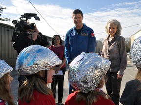 Lt.-Col Jeremy Hansen greets a group of students at Byron Northview public school in London April 14, 2015. Also pictured is Grade 6 teacher Vandana Bhalla (left) and Bonnie Schmidt, president and founder of the charitable organization Let’s Talk Science. CHRIS MONTANINI\LONDONER\POSTMEDIA NETWORK