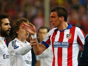 Atletico Madrid's Mario Mandzukic (right) clashes with Real Madrid's Dani Carvajal (left) during their UEFA Champions League Quarterfinal first leg match in Madrid on Tuesday, April 14, 2015. (Juan Medina/Reuters)