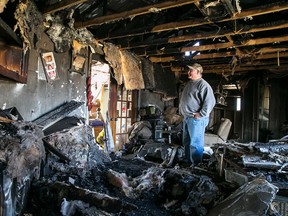 TIM MILLER/THE INTELLIGENCER
Ron Maracle stands in the remains of his living room on Tuesday. A photo of his grandchildren is one of few remaining items from a fire that destroyed the home his family has lived in for the last 43 years.