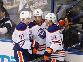 Edmonton Oilers' Ryan Nugent-Hopkins (L) and Taylor Hall (C) celebrate Jordan Eberle's (R) goal during the first period of their NHL hockey game against the St. Louis Blues in St. Louis, Missouri March 26, 2013. Nugent-Hopkins and Hall assisted with the goal. (REUTERS/Sarah Conard file photo)
