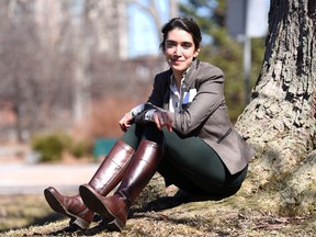 Sanna Masud, a fourth-year Queen's University Biology student, sits by a tree near the Queen's University Bioscience Complex  on Wednesday. (James Paddle-Grant/For The Whig-Standard)