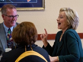 U.S. presidential candidate Hillary Clinton (R) talks with local residents as she campaigns for the 2016 Democratic presidential nomination at the Tremont Grille in Marshalltown, Iowa April 15, 2015. REUTERS/Rick Wilking