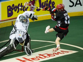 Edmonton goal keeper Aaron Bold (77) moves to block Calgary forward Curtis Dickson (17) during a NLL game between the Edmonton Rush and the Calgary Roughnecks at Rexall Place in Edmonton, Alta., on Saturday, April 11, 2015. The play was ruled a crease violation upon review by officials. Ian Kucerak/Edmonton Sun/Postmedia Network