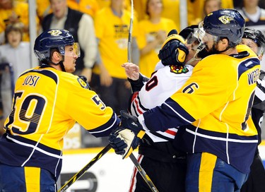 Nashville Predators defenseman Roman Josi takes a swing at Chicago Blackhawks left winger Patrick Sharp as he is pulled away by defenseman Shea Weber during the first period in Game 1 of the first round of the 2015 NHL playoffs at Bridgestone Arena on April 15, 2015. (Christopher Hanewinckel/USA TODAY Sports)