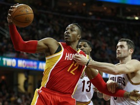 Houston Rockets centre Dwight Howard (12) grabs a rebound while being grabbed by Cleveland Cavaliers forward Kevin Love during NBA play at Quicken Loans Arena. (Ron Schwane/USA TODAY Sports)