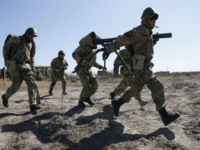 Newly mobilized Ukrainian paratroopers carry an anti-tank grenade launcher during a military drill near Zhytomyr April 9, 2015. REUTERS/Valentyn Ogirenko