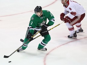 John Klingberg #3 of the Dallas Stars skates the puck against Sam Gagner #9 of the Arizona Coyotes at American Airlines Center on November 20, 2014 in Dallas, Texas.  Ronald Martinez/Getty Images/AFP