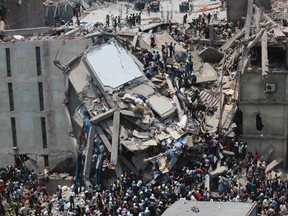 People rescue garment workers trapped under rubble at the Rana Plaza building after it collapsed, in Savar, 30 km (19 miles) outside Dhaka in this April 24, 2013 file photo. REUTERS/Andrew Biraj/Files