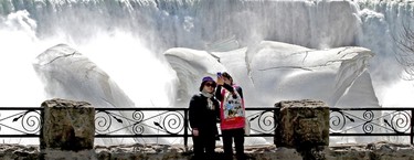 Tourists gather around Niagara Falls in the mild sunny conditions for a look at the mighty cataracts, where the icy grip of winter is not letting go so easily on Monday, April 13, 2015. (Mike DiBattista/Niagara Falls Review/Postmedia Network)