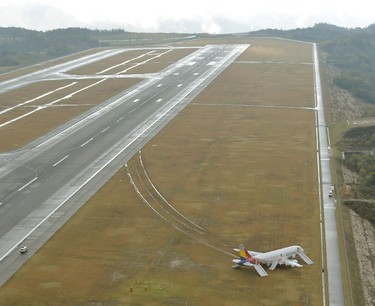 An aerial view shows an Asiana Airlines airplane which ran out of runway after landing at Hiroshima airport in Mihara, Hiroshima prefecture, western Japan, in this photo taken by Kyodo, April 15, 2015. An investigation has been launched after the passenger jet skidded off the runway on Tuesday, local media reported. (REUTERS/Kyodo)