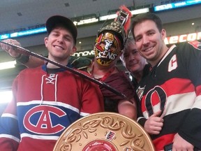 Brian Peterson, a diehard Sens fan decked out in Centurion armour pretends to slice Habs fan Colin Reid. Chris Kuhn, far right, and Guy Cadieux, middle right, weren't in any rush to stop Peterson. They were some of the several thousand who packed the Canadian Tire Centre to watch Game 2 between the Sens and Habs on Friday, April 17/2015 
(Keaton Robbins/Ottawa Sun/Postmedia Network)