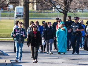 Community members and police return from the "Not Afraid" walkabout through the 404 Driftwood Ave complex on April 17, 2015. (Ernest Doroszuk/Toronto Sun)