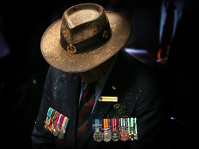 A veteran wearing service medals bows his head during a remembrance service on ANZAC Day in central Sydney, in this April 25, 2014 file photo. (REUTERS/David Gray/Files)