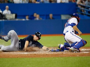 Atlanta Braves designated hitter Chris Johnson  beats the throw to Toronto Blue Jays catcher Russell Martin to score in the fifth inning at Rogers Centre on April 17, 2015. (John E. SokolowskiéUSA TODAY Sports)