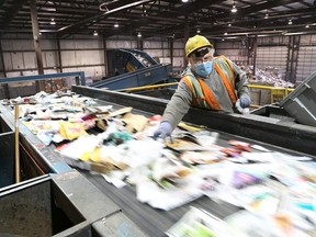 A worker sorts newsprint and fine paper at a sorting line at the recycling centre in Sudbury. (John Lappa/Sudbury Star file photo)