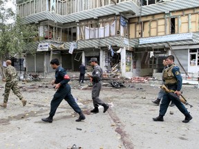 Afghan policemen arrive at the site of a suicide attack in Jalalabad April 18, 2015. The suicide bomb blast in Afghanistan's eastern city of Jalalabad killed 33 people and injured more than 100 outside a bank where government workers collect salaries, the city's police chief said on Saturday. REUTERS/Parwiz