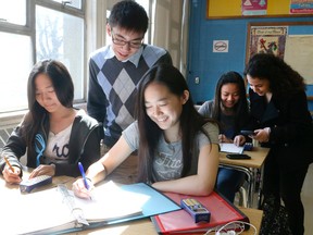 Brandon Chang, 17, Grade 12 takes a look at some work in a Grade 9 class along with Grade 12 student Vanessa Castiglione (right, behind ) at William Lyon Mackenzie Collegiate Institute on April 15, 2015.(Veronica Henri/Toronto Sun)