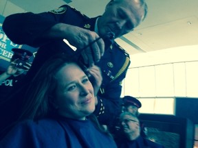 Chief Bill Blair shaves Det. Sgt. Amy Davey's head at Saturday's Cops for Cancer event to raise money for the Canadian Cancer Society. (Kevin Connor/Toronto Sun)