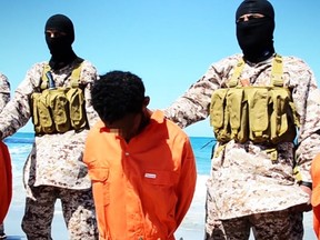 An image grab taken on April 19, 2015 from a video reportedly released by the Islamic State (IS) group through Al-Furqan Media, one of the Jihadist platforms used by the militant organization on the web, purportedly shows men described as Ethiopian Christians captured in Libya kneeling on the ground in front of masked militants before their beheading on a beach at an undisclosed location in Libya. AFP PHOTO / HO / AL-FURQAN MEDIA