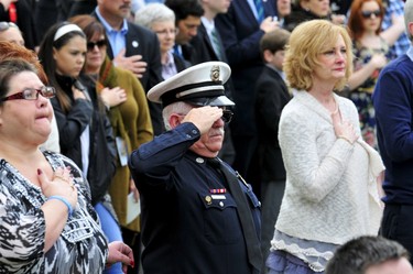A member of the Oklahoma City police department salutes during the national anthem at the 20th Remembrance Ceremony, the anniversary ceremony for victims of the 1995 Oklahoma City bombing, at the Oklahoma City National Memorial and Museum in Oklahoma City, April 19, 2015. REUTERS/Nick Oxford