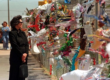 Patricia Roselius studies the thousands of memorials on the fence surrounding the site of the Murrah Federal Building in Oklahoma City, on the second anniversary of the bombing which destroyed the building, in this file photo taken April 18, 1997.  Sunday marks the 20th anniversary of the April 19, 1995 bombing - the nation's worst act of domestic terrorism - that killed 168 people.  Anti-government militant Timothy McVeigh, who conceived and carried out the attack, was executed in 2001. His accomplice Terry Lynn Nichols is in prison for life.  REUTERS/Staff/Files
