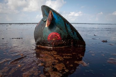 A hard hat from an oil worker lies in oil from the Deepwater Horizon oil spill on East Grand Terre Island, Louisiana, in this file photo taken June 8, 2010.   REUTERS/Lee Celano