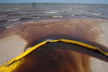 A protective boom is seen as oil from the Deepwater Horizon spill recedes back into the Gulf of Mexico after washing into a drainage canal in Waveland, Mississippi in this July 7, 2010 file photograph. REUTERS/Lee Celano/Files