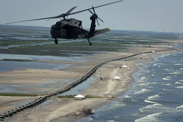 A helicopter carrying Louisiana Governor Bobby Jindal flies over a barrier of Hesco baskets as officials assess oil impact from the Deepwater Horizon spill in Fourchon Beach, Louisiana July 9, 2010. REUTERS/Lee Celano